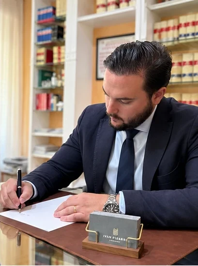 Iván Pizarro López firmando un documento en la mesa de su despacho